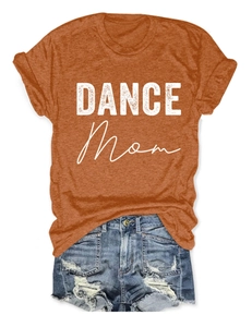 Detailed flat lay of a caramel DANCE Mom graphic t-shirt with distressed denim shorts