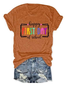 Dettaglio della stampa Happy First Day of School su una t-shirt arancione girocollo