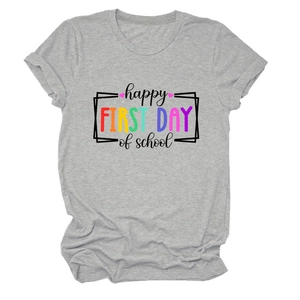 Dettaglio della maglietta grigia per la scuola con stampa happy first day of school e cotone