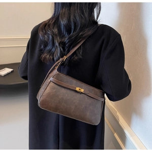 Dettaglio della borsa vintage in pelle marrone con finitura strutturata e chiusura dorata