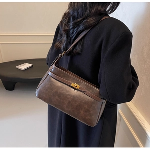 Dettaglio borsa a tracolla vintage in pelle marrone con chiusura dorata e cinturino