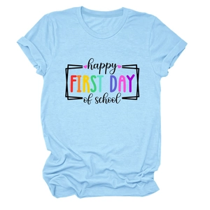 Dettaglio maglietta azzurra a girocollo con stampa Happy First Day of School e un cuore