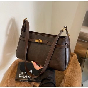 Dettaglio della borsa in pelle marrone scuro con elegante chiusura a scatto dorata