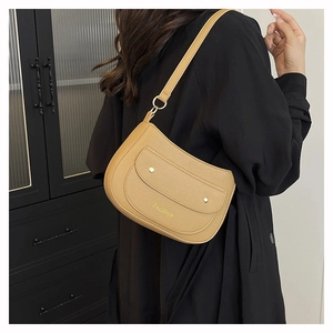 Detail of khaki lychee grain leather underarm bag with gold rivets and fashion logo
