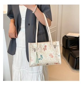 Detail of off-white jacquard tote bag with traditional Chinese embroidery and teal tassel