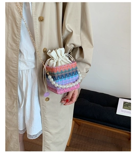 Fashion colorful woven bucket bag with pearl handle and chain strap on a stylish model