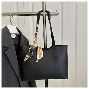 Detail of black tote bag with decorative silk scarf on handle for office look
