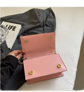 Detailansicht der rosa Umhängetasche mit zwei goldenen Magnetverschlüssen und Kette