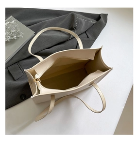 Top view of the spacious interior with golden zipper pocket in cream tote bag
