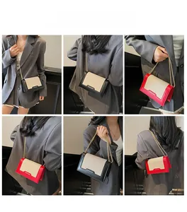 Detailansicht der Canvas-Leder-Umhängetasche mit goldener Kette in Rot und Schwarz