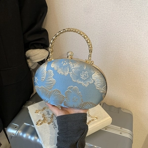Light blue cheongsam clutch with gold floral embroidery and metal handle detail