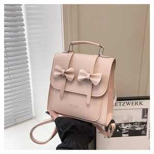 Detail of light pink PU leather backpack with delicate double bows and top handle
