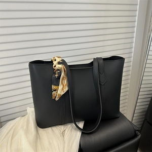 Minimalist black PU leather tote bag with elegant patterned silk scarf on handle