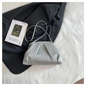 Macro detail of silver woven texture and fold design on minimalist shell crossbody bag