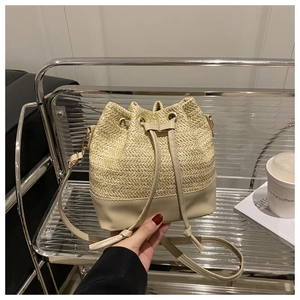 Détail d'un sac seau en paille tissée avec garniture en cuir sur support métal