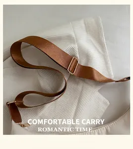 Detail of white nylon tote bag with brown woven strap and golden metal buckle hardware