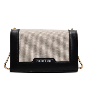 Elegante Schultertasche aus beigem Canvas mit schwarzem Lederbesatz und Goldkette