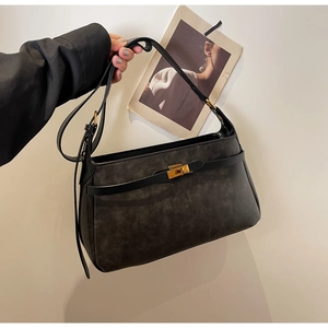 Primo piano di una borsa a spalla in pelle grigio antracite con chiusura a scatto dorata