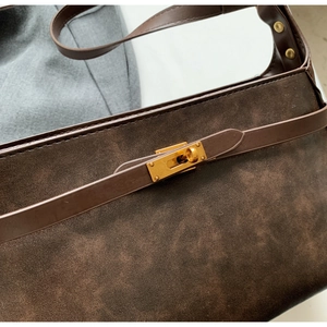 Dettaglio borsa a tracolla marrone vintage con chiusura dorata e texture opaca