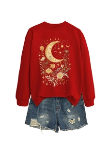 Dettaglio della stampa retrò luna e fiori su felpa rossa con pantaloncini di denim