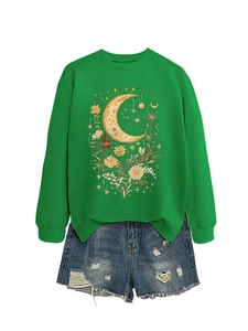 Dettaglio della stampa retrò con luna e fiori sulla felpa verde e shorts in denim