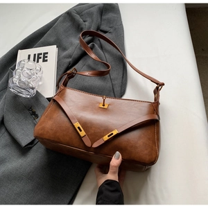 Dettaglio borsa vintage marrone con chiusura dorata e materiale in pelle testurizzata