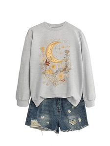Dettaglio felpa grigia da donna con grafica vintage luna e fiori e pantaloncini denim