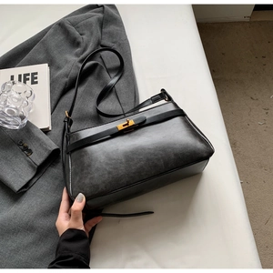 Primo piano della borsa vintage nera con trama in pelle opaca e chiusura con fibbia dorata