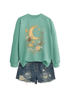 Dettaglio felpa verde menta con stampa luna floreale e pantaloncini denim usurati