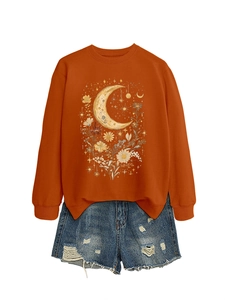 Dettaglio della felpa arancione con stampa luna e fiori e pantaloncini in denim strappati