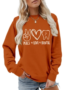 Detail of peace love dental graphic print on burnt orange crewneck sweatshirt