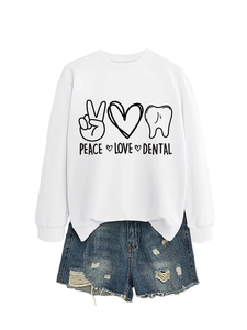 Detail of Peace Love Dental print on white long sleeve sweatshirt with ripped denim shorts