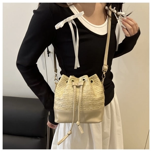 Détail du sac seau en paille avec base en cuir et bandoulière réglable