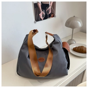 Dettaglio borsa tote in nylon grigio scuro con logo fashion e tracolla marrone