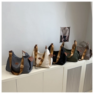 Collection of nylon tote bags in five colors with wide woven straps and fashion labels