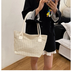 Detail of chevron woven tote bag with ivory leather handles for beach or commute