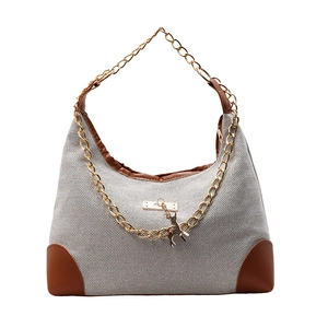 Borsa tote in nylon grigio con catena dorata e ciondolo a forma di cervo su sfondo bianco