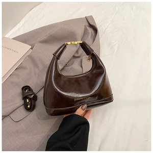 Détail du sac hobo marron foncé brillant avec boucle en métal doré et lettrage fashion