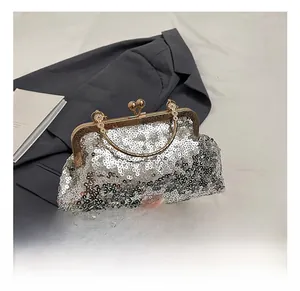 Detailed shot of silver sequin evening bag with gold metal clasp and beaded handle