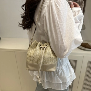 Sac seau minimaliste en paille tressée beige avec bandoulière en cuir pour femme