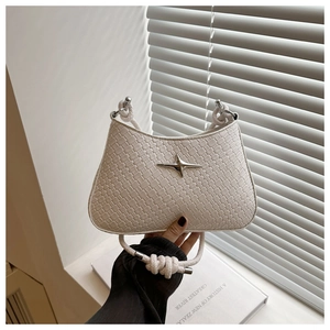 Détail du sac tressé blanc avec une étoile argentée et une poignée en corde nouée