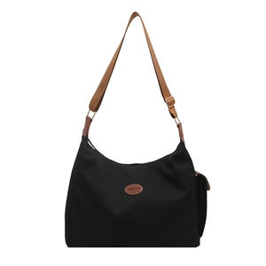 Minimalist black nylon crossbody bag with wide brown strap and fashion oval patch