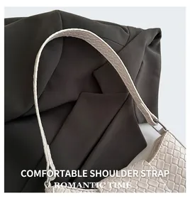 Detailaufnahme der cremefarbenen Flechtstruktur und des Lederriemens der Schultertasche