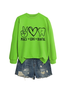 Flat lay of neon green sweatshirt with Peace Love Dental print and ripped denim shorts