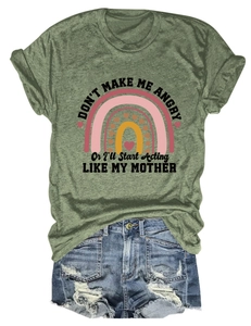 Detail view of dark green t-shirt with rainbow print and blue distressed denim shorts