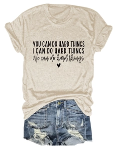 Detailed flat lay of beige cotton T-shirt with inspirational text and denim shorts