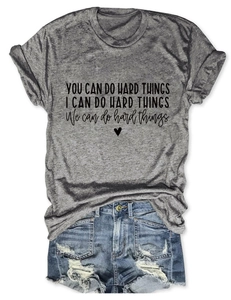 Flat lay detail of grey t-shirt with heart graphic and ripped denim shorts