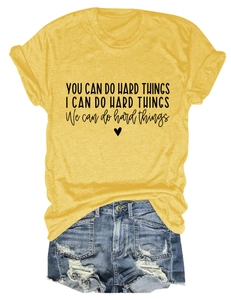 Flat lay of yellow t-shirt with inspirational quote and distressed denim shorts set
