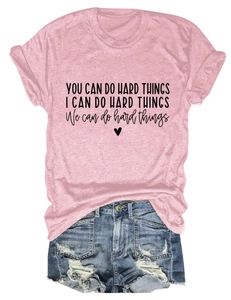 Detailed flat lay of pink t-shirt with inspirational text and ripped denim shorts