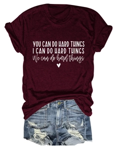 Close-up of burgundy crew neck tee with white quote print and distressed denim shorts